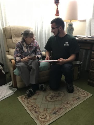 Corpsmember explaining efficiency savings to an elderly woman