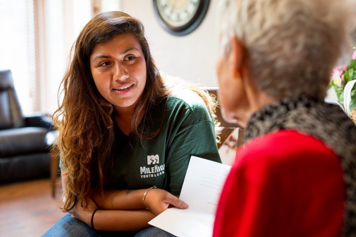 Corpsmember speaking with elderly woman.