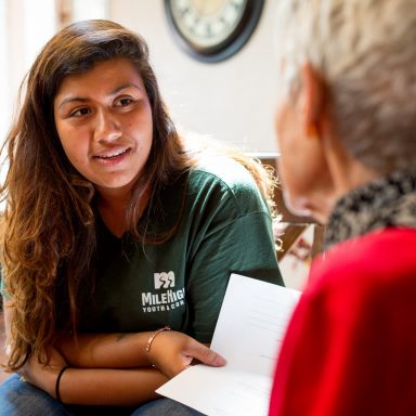 Corpsmember speaking with elderly woman.