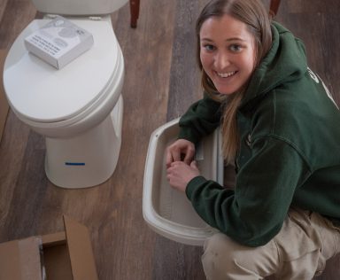 Corpsmember installing a toilet.